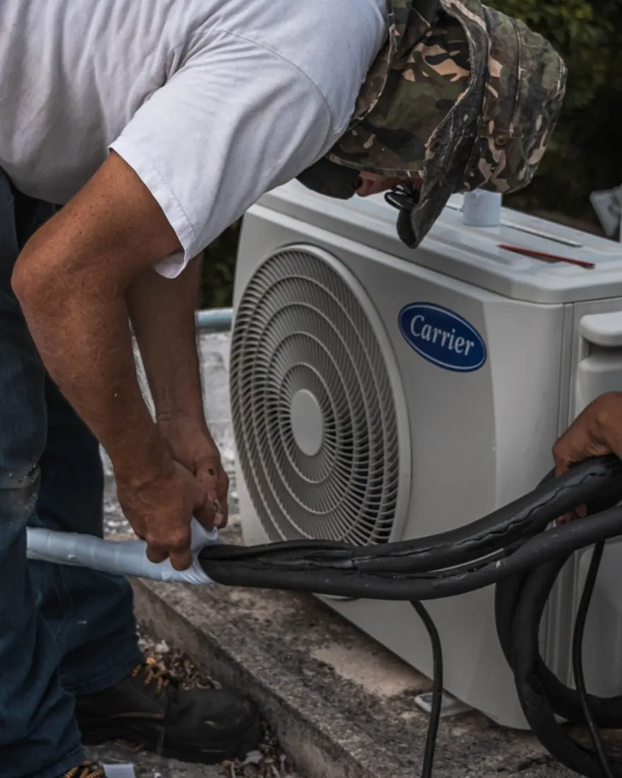 Técnico limpando ar-condicionado cassete no teto de uma loja